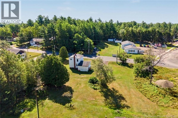 High aerial view of the property showcasing the house, its large lot, and the rural neighborhood. - 21 Red Bank Drive, Chipman
