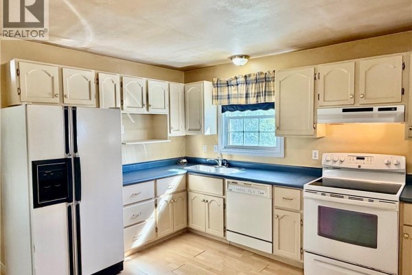 Kitchen with light wood cabinets, white appliances, and a blue countertop. - 21 Second Street, Miramichi