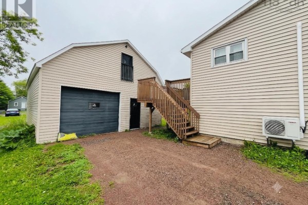 Close-up of the detached garage with a dark gray door and wooden exterior stairs. - 21 Snowden Avenue, Amherst