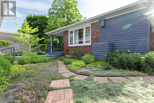 Covered blue deck with a blue Adirondack chair, overlooking a yard with bare trees. - 21 Spring Garden Road, Middleton