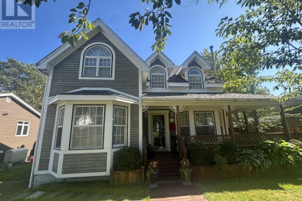 Front view of a grey house with a covered porch, bay window, and arched dormers. - 21 Symonds Place, St  John’s