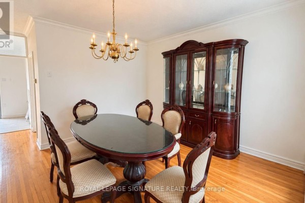 Dining room with oval glass-top table, chairs, and a large wooden china cabinet. - 21 Via Italia, Toronto
