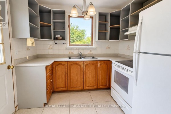 U-shaped kitchen with white countertops, light wood cabinets, and a window above the sink. - 21 Via Italia, Toronto
