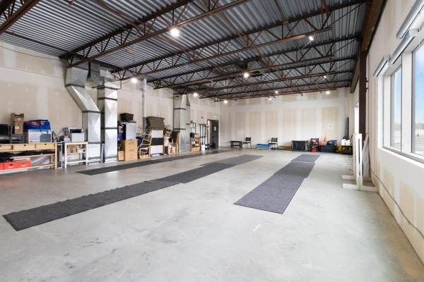 View of industrial ductwork and storage in a large commercial interior space. - 210, 450 Ordze Road, Sherwood Park