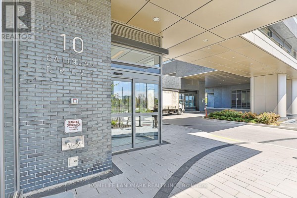 Entrance to 10 Gatineau Drive building with glass doors and grey tiled walls. - 210 - 10 Gatineau Drive, Vaughan
