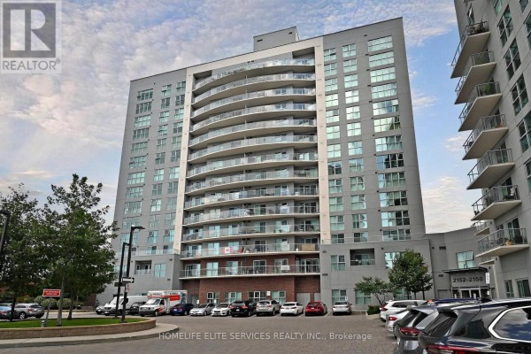 Side view of a modern apartment building with glass balconies and dark grey exterior. - 210 - 2152 Lawrence Avenue E, Toronto