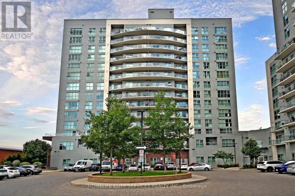 Apartment building with balconies and surrounding parking lot, featuring a circular green island. - 210 - 2152 Lawrence Avenue E, Toronto