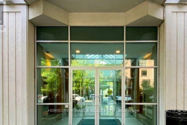 Exterior of an apartment building entrance with glass doors and windows. - 210 - 31 Bales Avenue, Toronto