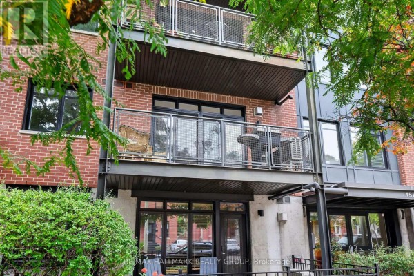 Balconies on the apartment building feature metal railings and outdoor furniture, with brick walls. - 210 - 457 Mcleod Street, Ottawa