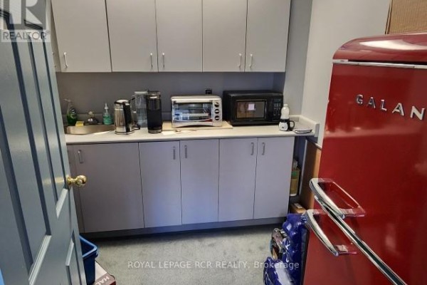 Break room with appliances including a red refrigerator and coffee machines - 210 - 712 Davis Drive, Newmarket
