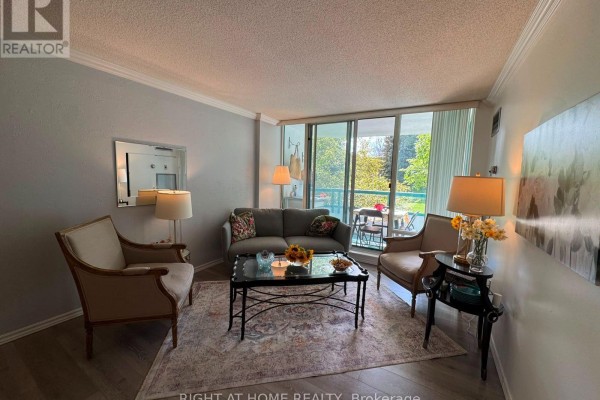 Living room featuring a sofa, two armchairs, a coffee table, and a balcony visible through floor-to-ceiling windows. - 210 - 7250 Yonge Street, Vaughan