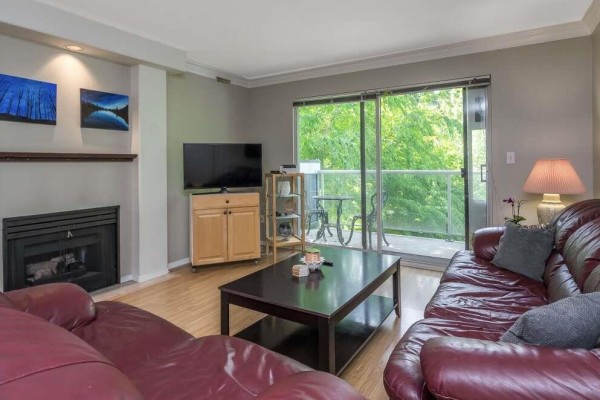 Lobby area with glass doors, stone flooring, and seating arrangements. - 210 20177 54a Avenue, Langley