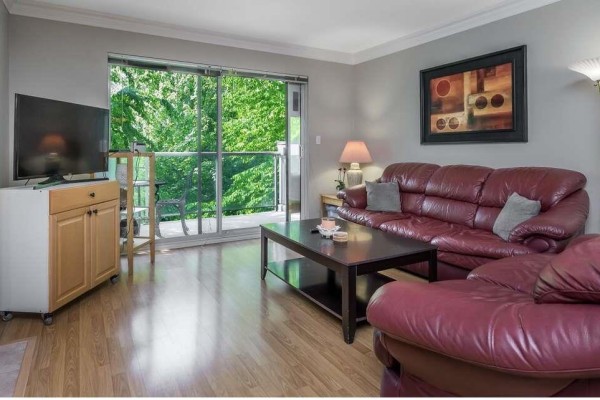 Hallway entrance with light-colored walls and wooden flooring leading to dining area. - 210 20177 54a Avenue, Langley