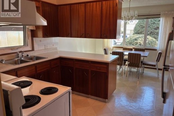Kitchen and dining area with a table, chairs, and large window with trees outside. - 210 Alexander Avenue, Canora