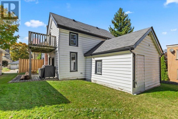 Backyard view of the house with a wooden balcony and detached garage. - 210 Colborne Street S, Brockton