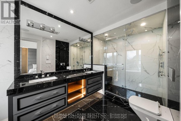 Modern bathroom with double vanity, glass shower, and marble tile - 210 Horsham Avenue Toronto