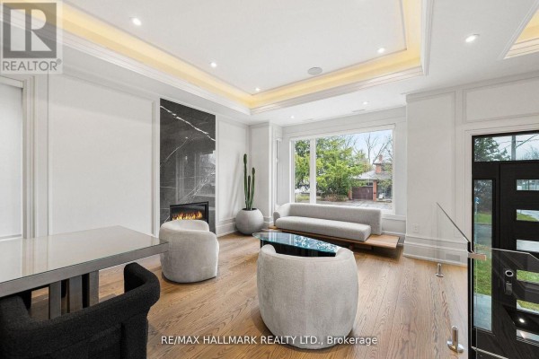 Living room with hardwood floors, fireplace, large window overlooking the street, and contemporary seating. - 210 Horsham Avenue, Toronto