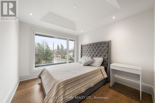 Bedroom with tufted headboard, large window and desk - 210 Horsham Avenue Toronto