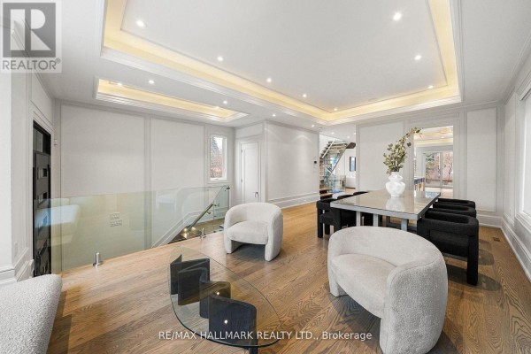 Living room with boucle chairs, glass coffee table, and modern staircase - 210 Horsham Avenue Toronto