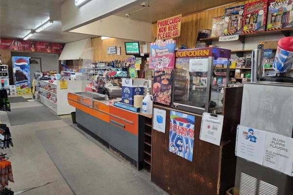 Interior of a convenience store with a checkout counter, shelves, and snack displays. - 201 Main Street, Langruth