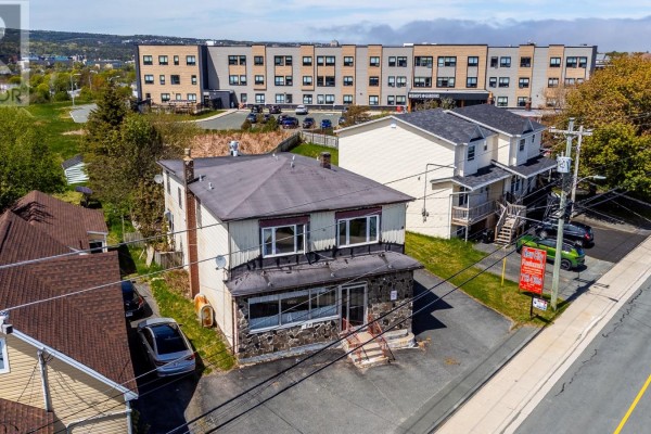 Side view of the commercial property with surrounding houses and businesses. - 210 Pennywell Road, St  John S
