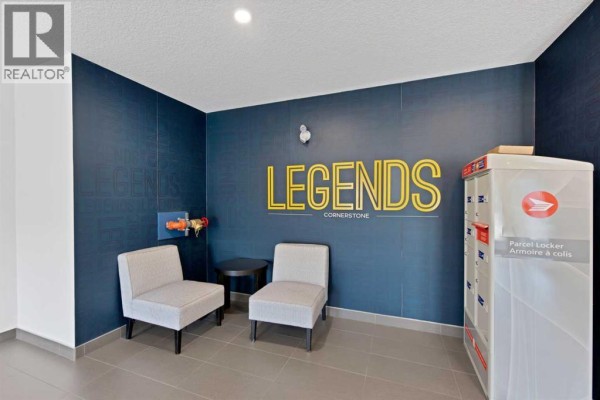 Interior lobby area with a blue accent wall, mailboxes, and seating. - 2101, 76 Cornerstone Passage Ne, Calgary