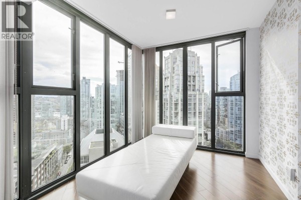 White chaise lounge in a room with corner windows offering city views. - 2102 1155 Homer Street, Vancouver