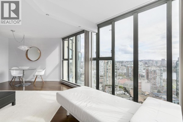 Living room area with a sofa, chaise lounge, and panoramic city views through large windows. - 2102 1155 Homer Street, Vancouver