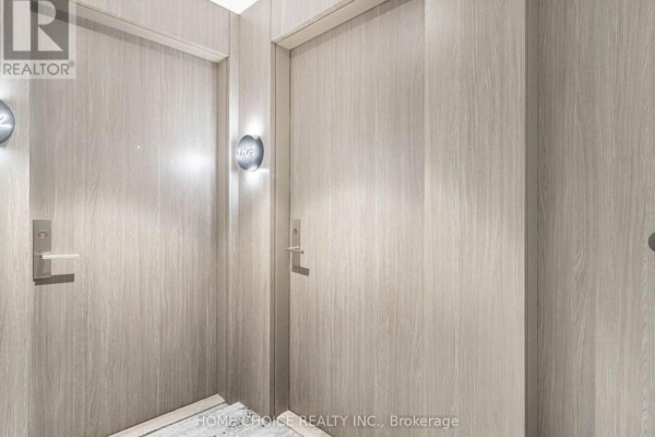 Interior view of apartment doors with wood-grain finish and modern light fixtures. - 2103 - 161 Roehampton Avenue, Toronto