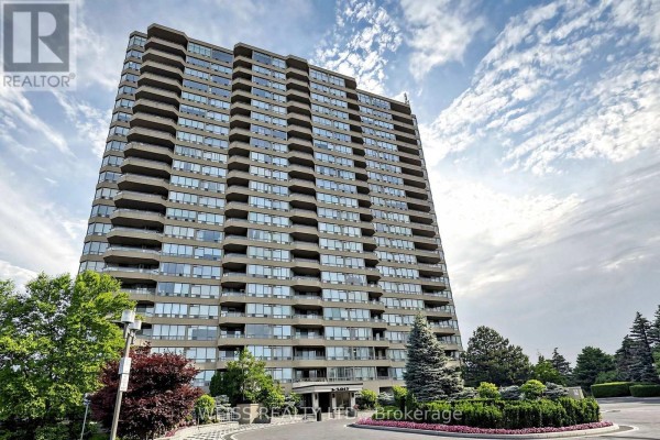 Low angle exterior view of a tall apartment building entrance with landscaping and trees. - 2104 - 10 Torresdale Avenue, Toronto