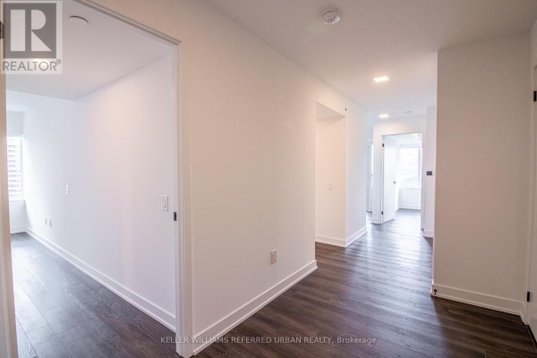 Hallway with white walls, dark wood floors, and doors leading to rooms. - 2104 - 609 Sherbourne Street, Toronto