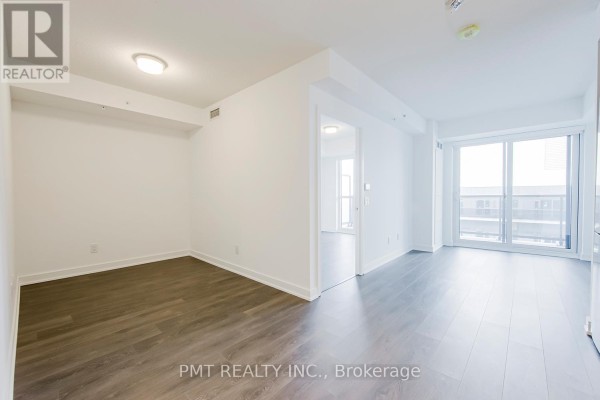 Empty living room with white walls, dark wood floors, and a sliding glass door. - 2105 - 30 Samuel Wood Way, Toronto
