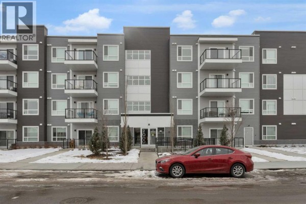 Front view of the building featuring balconies and a red car parked in front. - 2106, 33 Carringham Gate Nw, Calgary