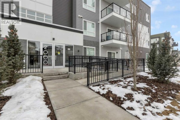 Entryway with a white door, light gray walls, and wooden flooring. - 2106, 33 Carringham Gate Nw, Calgary