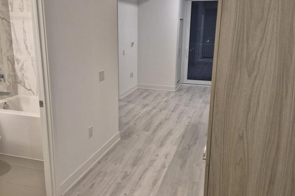 Interior view of a bathroom with a bathtub and an adjacent living area. - 2106 - 36 Olive Avenue, Toronto