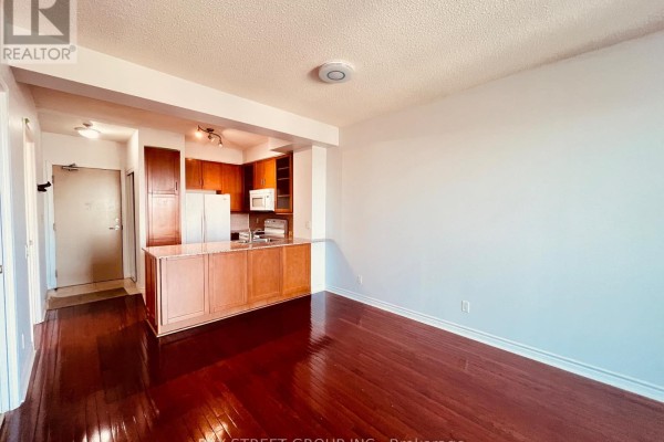 Open-concept living space with dark hardwood floors and a kitchen island. - 2107 - 60 Byng Avenue, Toronto