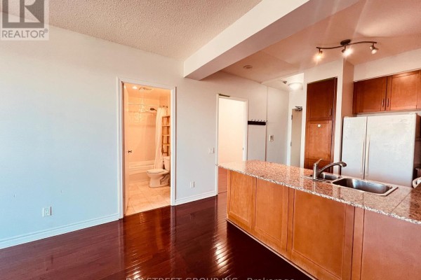 View of the kitchen island, bathroom entrance with bathtub, and living area. - 2107 - 60 Byng Avenue, Toronto