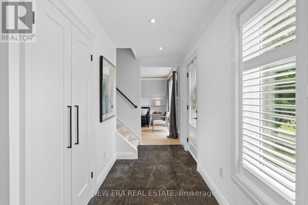 Interior hallway with dark floor tiles, white walls, and staircase. - 2107 Russett Road, Mississauga