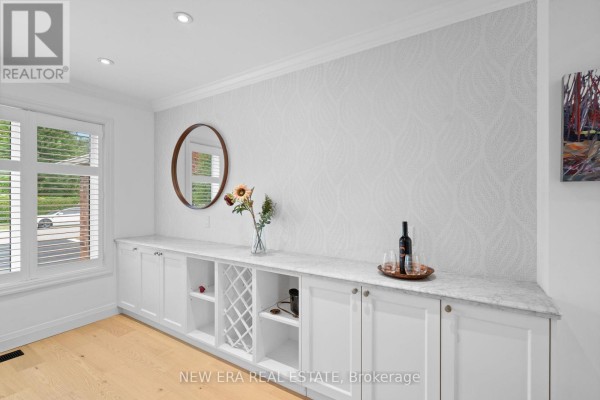 Built-in white cabinets with wine rack and marble countertop in a bright room. - 2107 Russett Road, Mississauga