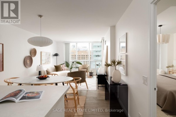 View of the living area and open doorway leading to the bedroom with a king-sized bed. - 2109 - 750 Bay Street, Toronto