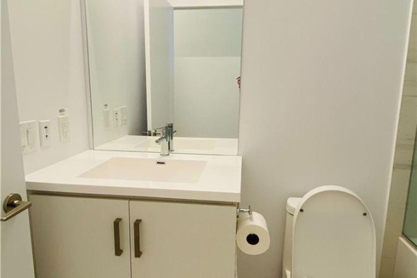 Close-up of a white vanity, sink, and toilet in a light-coloured bathroom. - 211 - 10 Honeycrisp Crescent, Vaughan