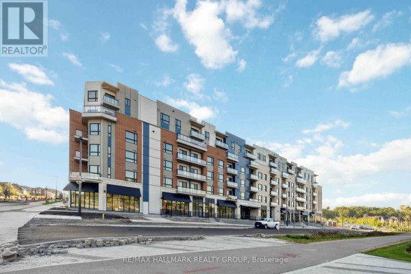 Exterior view of a modern, multi-story apartment building with balconies under a blue sky. - 211 - 397 Codds Road, Ottawa