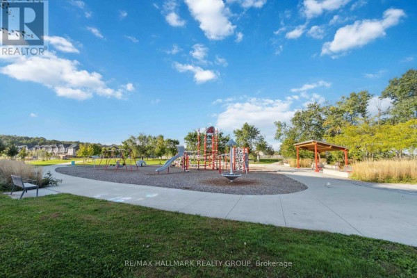 Children's playground with swings, slides, and a spinning toy in a park setting. - 211 - 397 Codds Road, Ottawa