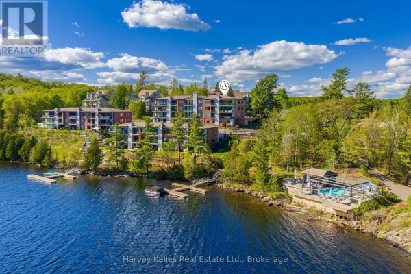Open concept living and dining area with large windows and lake view. - 211 - 727 Grandview Drive, Huntsville