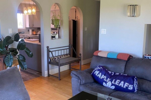 Living room with a grey sofa, plants, and arched openings to the kitchen area. - 211 11 Highway, Fauquier Strickland