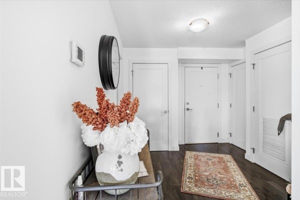 Open concept living room and kitchen with light grey walls and island. - #211 5029 Edgemont Bv Nw, Edmonton