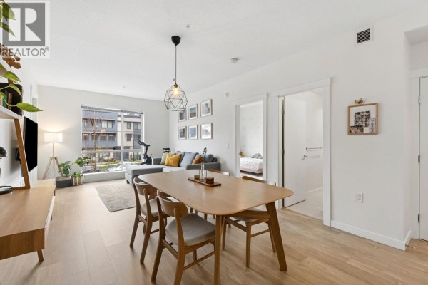 Cozy living space with dining table, sofa, and natural light from window - 211 625 E 3rd Street, North Vancouver