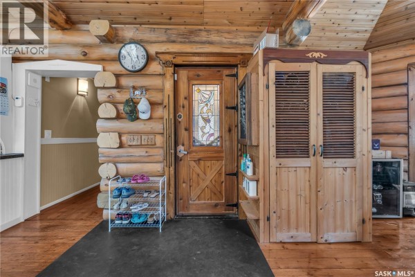 Interior entrance with a wooden door, shoe rack, and wooden storage unit. - 211 Al Drive, Turtle Lake