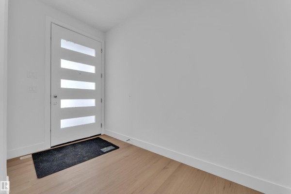 Interior view showing a carpeted room with large mirrors reflecting a staircase and window. - 211 Basin Co, Leduc