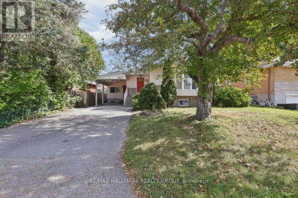 Side view of the house at 211 Harcourt Avenue with a driveway and green lawn. - 211 Harcourt Avenue, Ottawa
